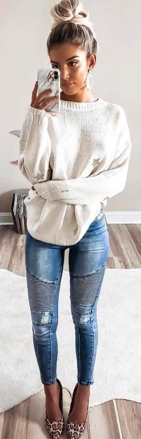 White crew-neck sweater with distressed blue denim jeans outfit.