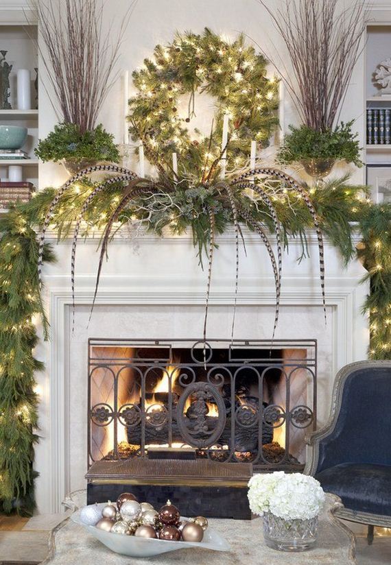 Hanging Green Christmas Wreath over White Wood Mantel with Green Leaves and Long Feathers on the Mantel.