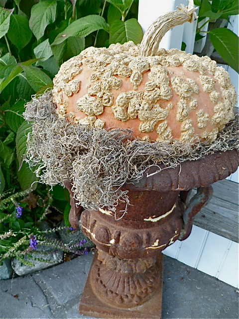 Pumpkin full of texture rests on a rusty urn.
