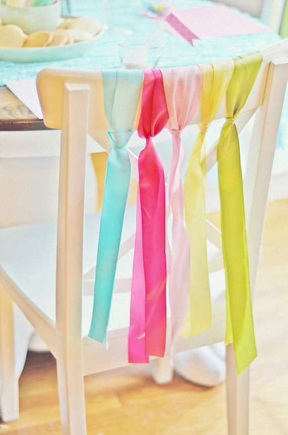 Tie the ribbon to the backs of the chairs.
