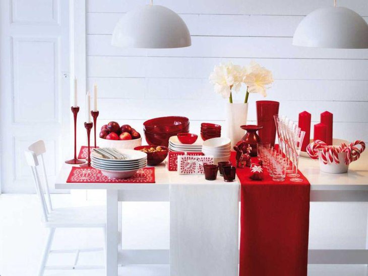 White Holiday Table with Red Runner, White Dishes, and Red and White Decorations.