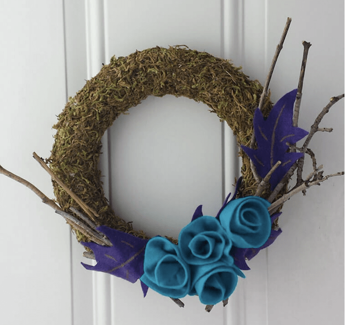 Colorful felt flowers on moss wreath.