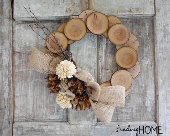 DIY wood slice wreath with burlap ribbon and dried flowers.