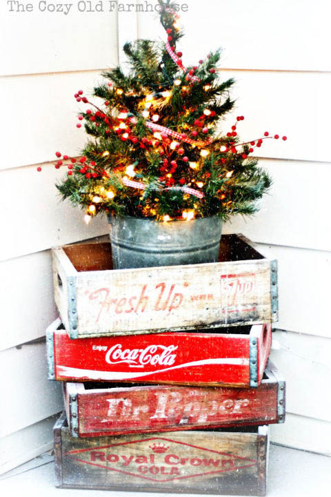 Place a mini decorated tree on a stack of vintage soda crates or a little red wagon.