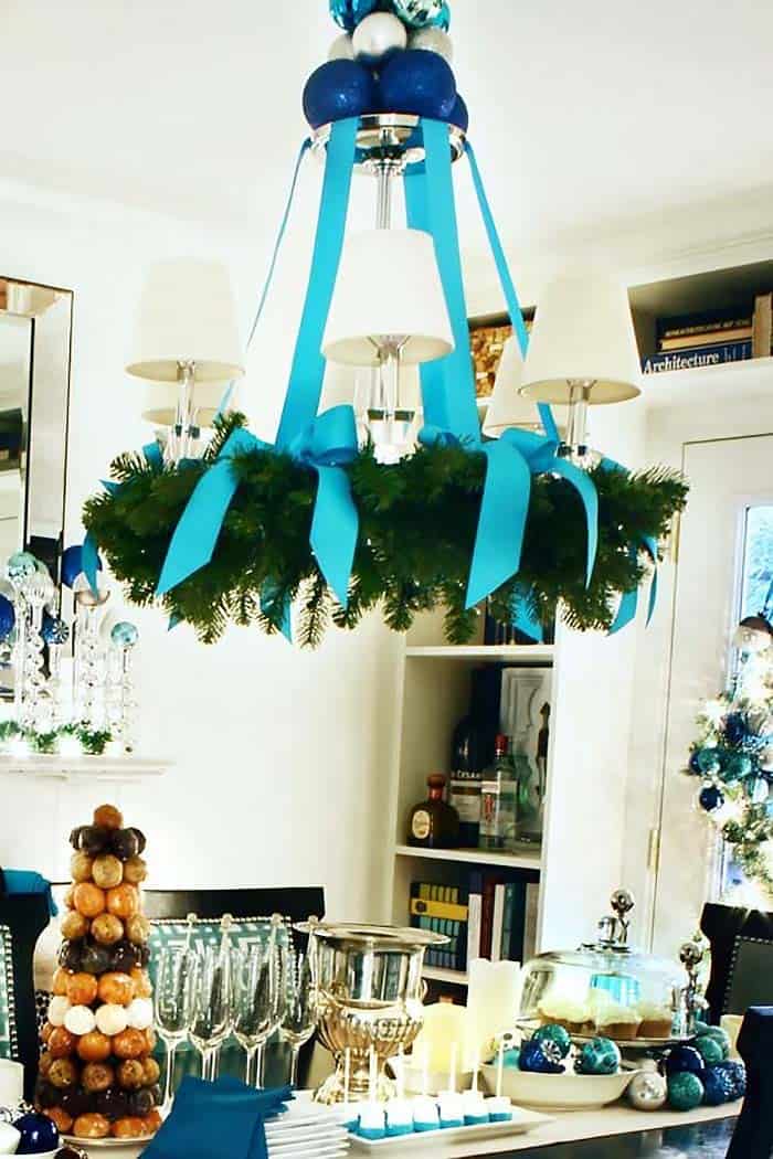Attach a wreath to the bottom of your chandelier with ribbons.