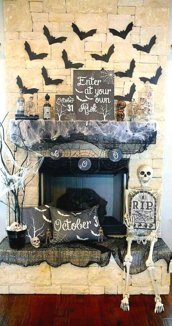 Classic Halloween Mantel decor with flying bats tree and skeleton.