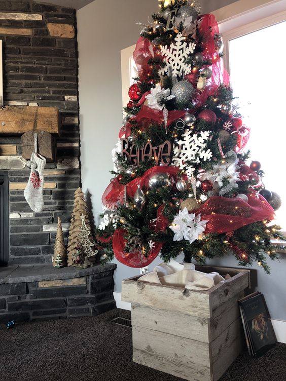 Red, white, and silver Christmas tree with barnwood box stand.