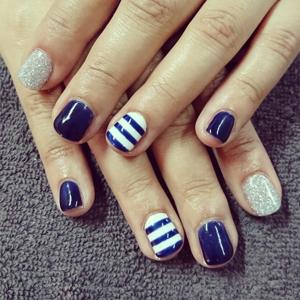 Navy nails with white stripes and silver glitter