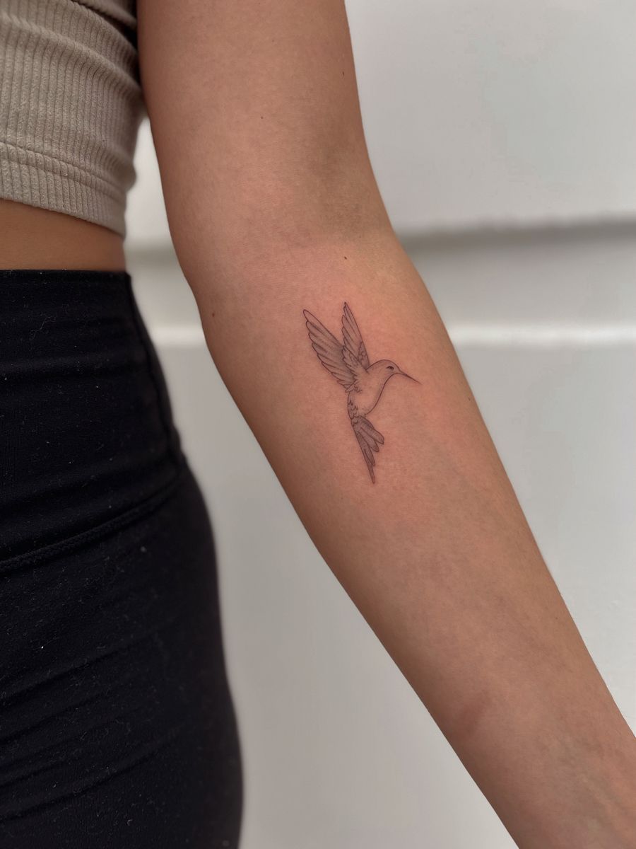 Feminine and simple hummingbird tattoo